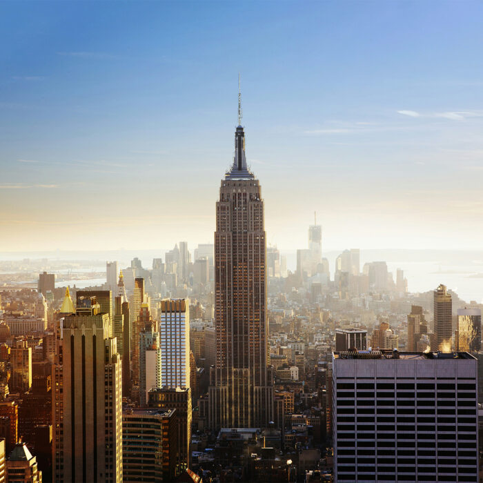 Aerial view of New York City featuring the Empire State Building at the center.