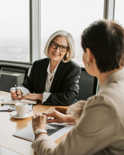 Two women in a bright office having a professional meeting.