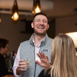 Two people mingling at a Stavtar event, enjoying drinks.